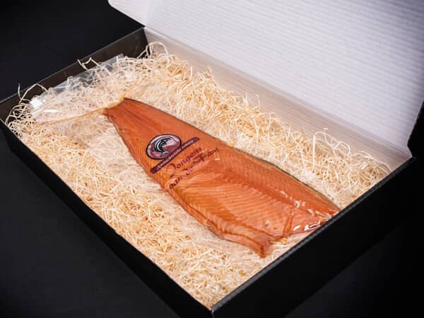 Geschenk verpakking geopend met warm gerookte zalm op stro