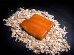 Warm gerookte zalm moot van 450 gram op rookmot en zwarte achtergrond