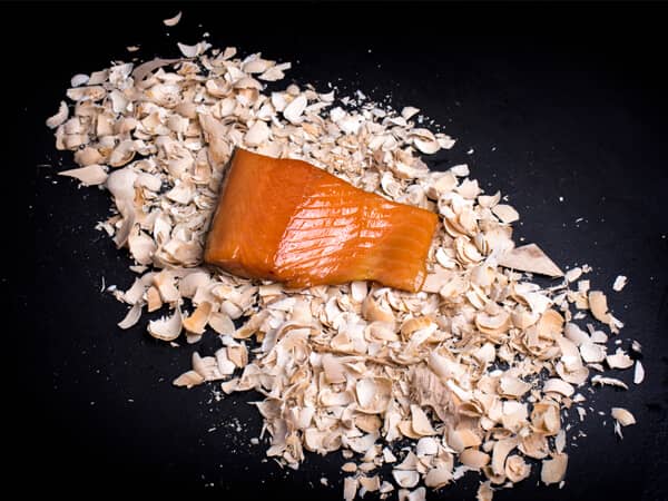 Warm gerookte zalm mootje op rookmot en zwarte achtergrond