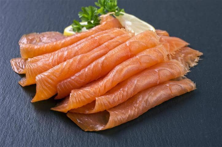 Koud gerookte zalm netjes gedrapeerd op steen