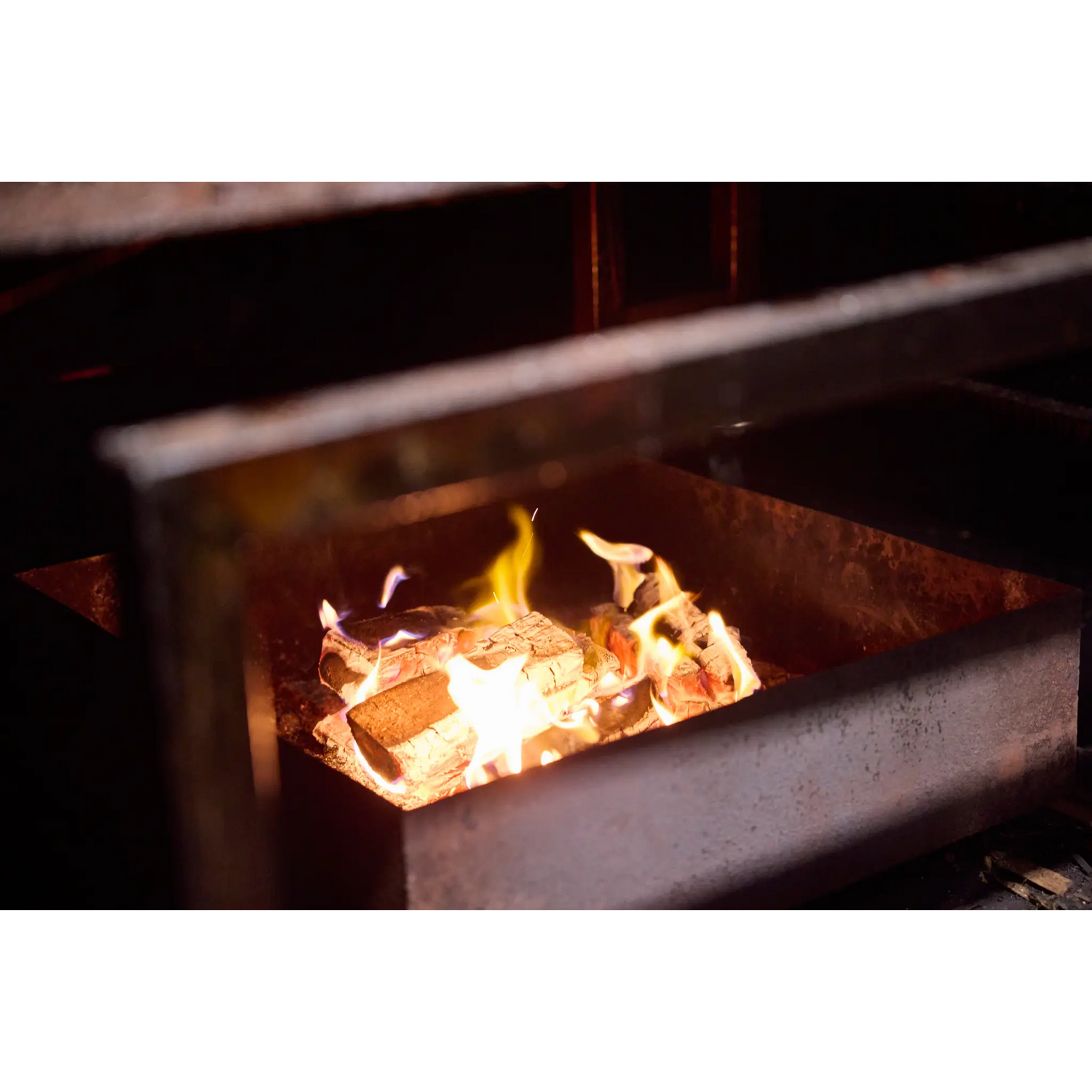 Houtvuur in de rokerij van Zalm van Urk tijdens het warm rookproces van zalm