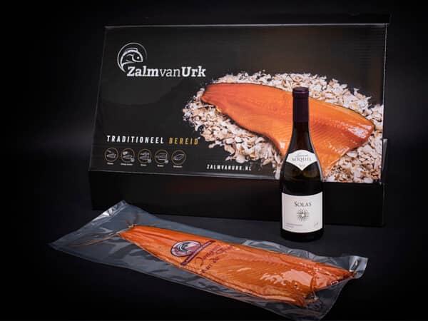 Gerookte zalm met fles wijn en zwarte geschenk verpakking